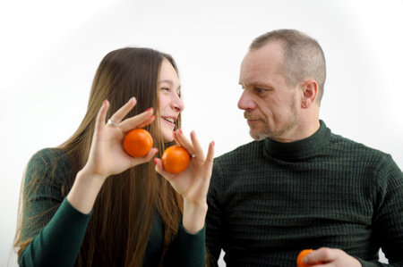 Adult man and young woman choose tangerines and cauliflower in vegetable shopの写真素材