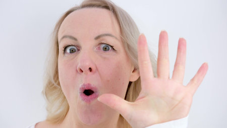 beautiful woman on a white background spreads her fingers 1 2 3 4 5 on palm of hand show score says...