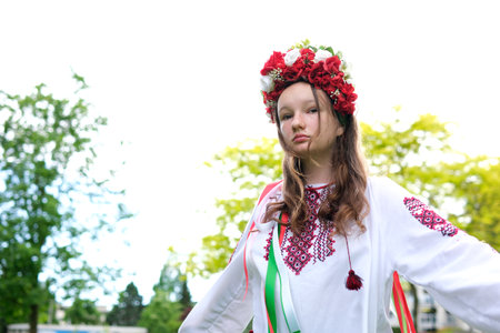 cute young girl teenager ukrainian woman in folk traditional develops her curls beautiful wreath with many flowers ribbons nature female natural beauty folk image nature trees foliage womanの写真素材
