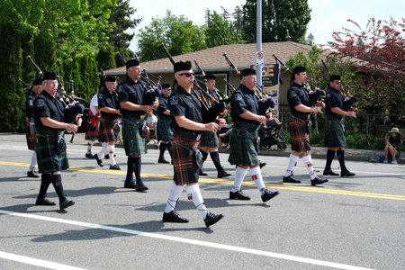 elderly men in Scottish skirts with bagpipes marching down the street during a gay pride parade...