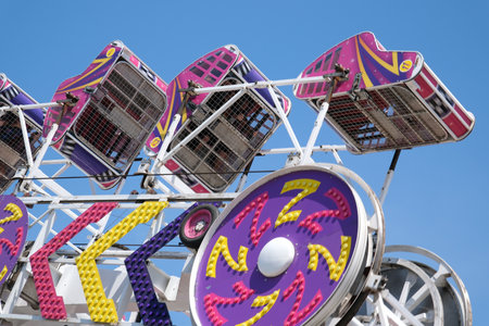 amusement park adults and children stroll against backdrop of swing. people have fun on summer autumn day. teenagers buy tickets spend time with family. large crowd of american people on holidayのeditorial素材