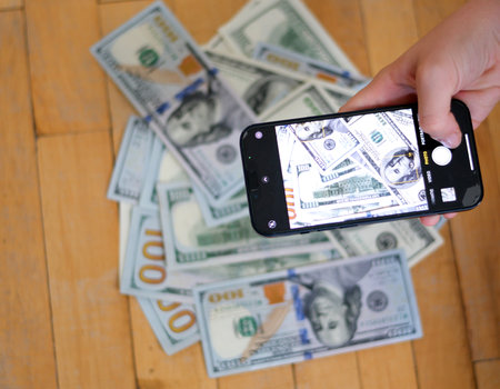 Smart Phone Extends Fanned 100 Dollar Billsの写真素材