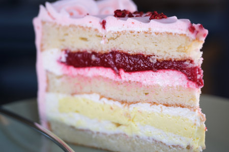 close-up of a piece of cake with cherries being unwrapped from the package. bakery cake. appetizing piece of cake with cherry. selective focusの写真素材