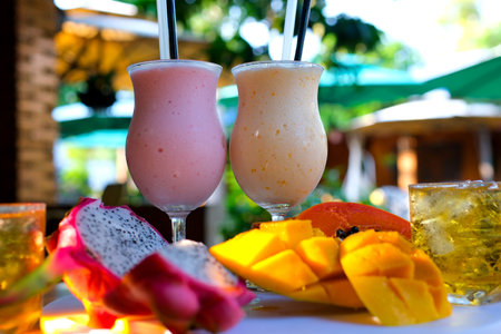 fresh fruit smoothies: strawberry banana smoothie, orange smoothie, green detox smoothie. Avocado juice. Fruit milkshake. Fresh strawberries. Wood table background. Natural sunlight. Healthy.の写真素材