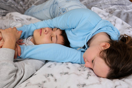 Tired, couple and cuddle with sleep in bedroom for marriage, commitment and comfort in love at home. Partner, peace and man with embrace of woman in house for dream, rest and afternoon nap on weekendの写真素材