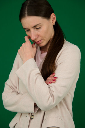Thoughtful Businesswoman in White Blazer Posing with Hand on Chin
