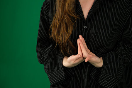 Happy mindful thankful middle aged woman holding hands on chest meditating with eyes closed isolated on grey background feeling no stress, gratitude, mental health balance, peace of mind concept.の写真素材