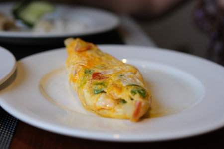 Stuffed omelette with tomatoes and spinach on light background with copy space. Top view, flat lay