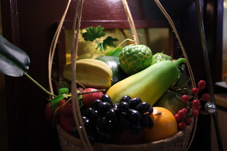 collection of fresh fruits and vegetables in a wooden basket on a table in a modern kitchen background blurの写真素材