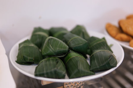 Banana leaf wrapper rotating on isolated white background. Fresh crabs neatly bundled in banana leaves, displayed for sale at a local market, highlighting traditional seafood preparation.の写真素材