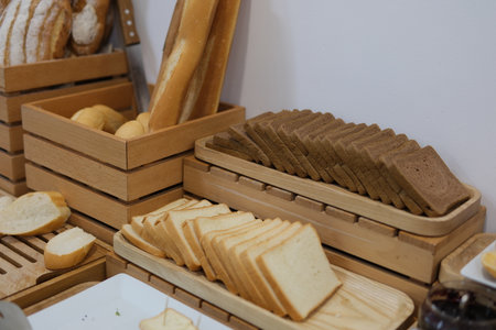 Freshly baked bread in wicker baskets. Rustic bread display in bakery. Handmade loaves with crusty...