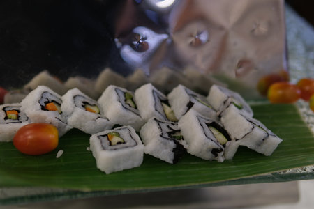Set of sushi rolls dragon on a black matte plate. Japanese traditional sushi dish with avocado, eel and soy sauce. A beautiful dish for an Asian restaurant menu.の写真素材