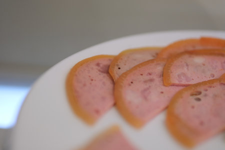 Pink meat slices Delicious canned pink ham with salt, spices and herbs on a dark concrete backgroundの写真素材