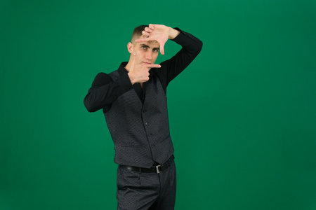 Set of videos with handsome European businessman in classic suit vest and black shirt showing different emotions gestures and confident poses on green chroma key background with copy spaceの写真素材