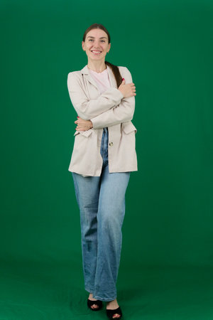 Set of photos of young European woman in light blazer and blue jeans showing various emotions gestures and expressions on green chroma key background with copy space for advertising and social mediaの写真素材