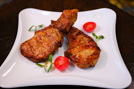 Grilled pork steaks, pork neck with herbs and spices on the grill pan, Restaurant menu, cookbook...