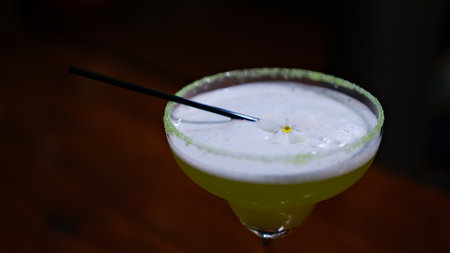 Margarita in a blue rimmed glass with lime on a wooden surfaceの写真素材