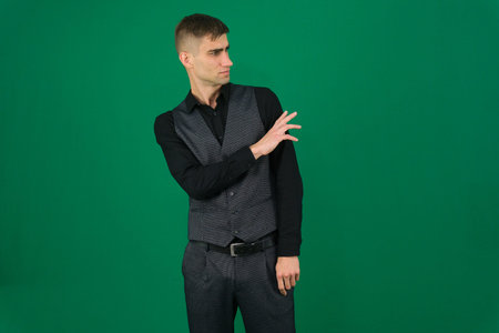 Various emotions and movements of a man in a gray suit on a green background in a vest and pants,...