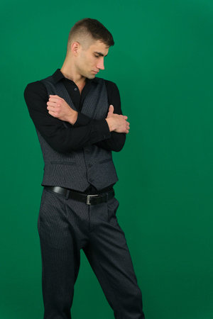 Various emotions and movements of a man in a gray suit on a green background in a vest and pants,...