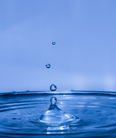 Drop of water falling on water levelの写真素材