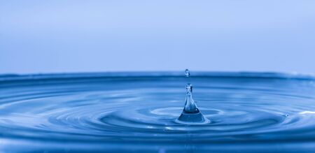 Drop of water falling on water levelの写真素材