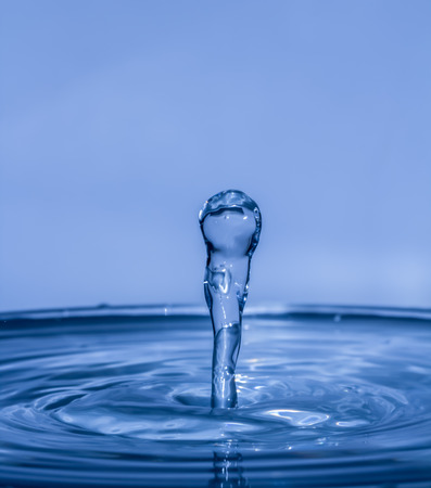 Drop of water falling on water levelの写真素材