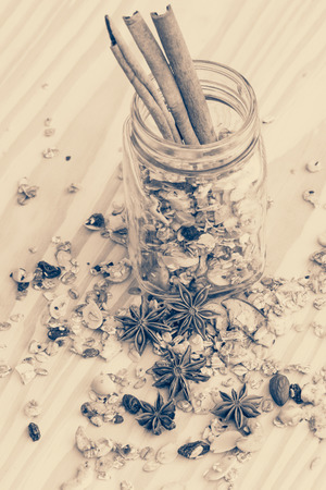 abstract of granola cereal and cinnamon sticks on the wood background,film style toningの写真素材