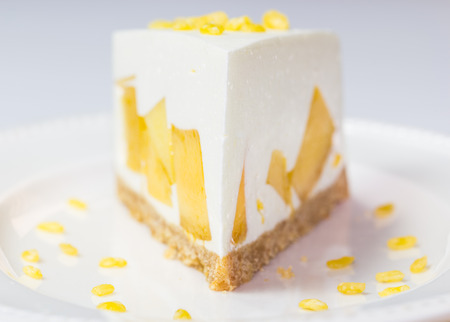 close up of mango cream pie with peeled split mung bean on white plateの写真素材