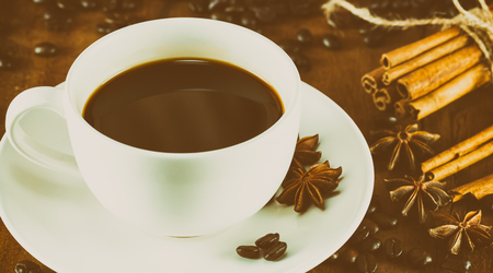 coffee on the cup with coffee beans and cinnamon sticks  , selective focus ,vintage toningの写真素材