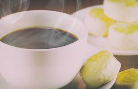 a cup of coffee and scone on wood background,vintage toning, selective focusの写真素材