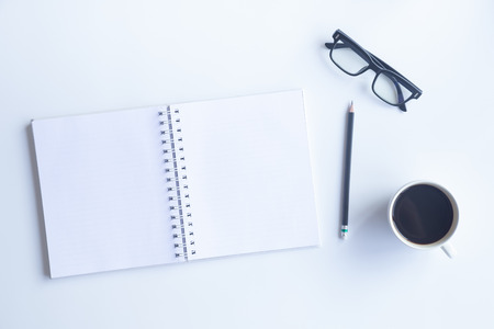 White desk office with laptop, smartphone and other work supplies with cup of coffee. Top view with...