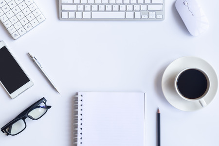 White desk office with laptop, smartphone and other work supplies with cup of coffee. Top view with copy space for input the text. Designer workspace on desk table essential elements on flat lay.の写真素材