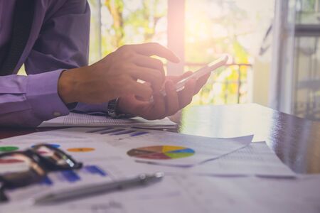 Businessman or accountant working on calculator to calculate business data concept. Accounting,investment advisor consulting situation on the financial report and planning a marketing plan at office.の写真素材