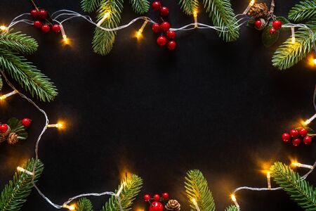 Holiday Christmas card background with festive decoration ball, stars, snowflakes, gift box, pine cones on a black background from Flat lay, top view. Space for text Merry Christmas and happy New Yearの写真素材