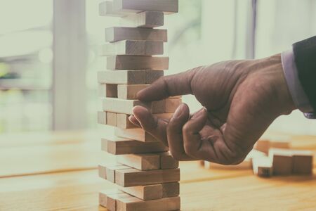 Business man gambling placing wooden block. Business concept  investment target and growth success process background present financial information planning, risk and marketing strategy analysis.の写真素材