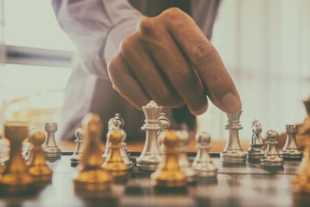 Chess game on chess board behind business man background. Business concept to present financial information and marketing strategy analysis. Investment target in global economy and digital commercial.の写真素材