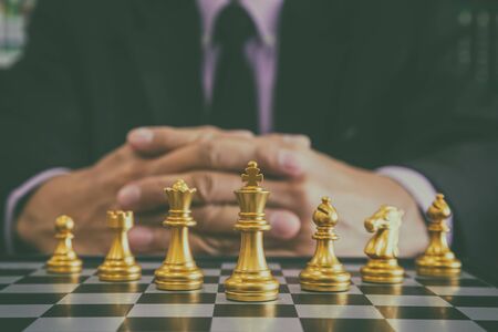 Chess game on chess board behind business man background. Business concept to present financial information and marketing strategy analysis. Investment target in global economy and digital commercial.の写真素材