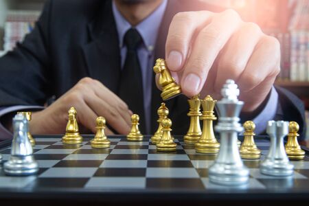 Chess game on chess board behind business man background. Business concept to present financial information and marketing strategy analysis. Investment target in global economy and digital commercial.の写真素材
