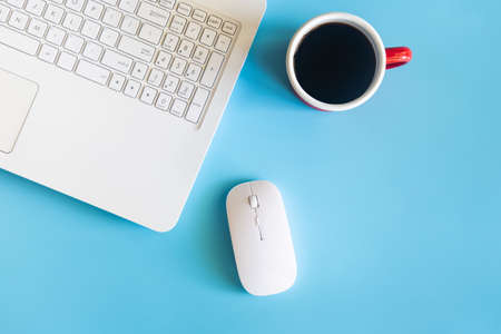Pastel blue desk office with laptop, smartphone and other work supplies with cup of coffee. Top view with copy space for input the text. Workspace on desk table essential elements on flat lay.の写真素材