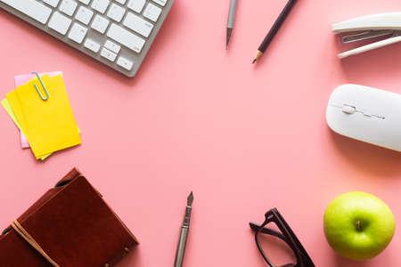 Pastel pink desk office with laptop, smartphone and other work supplies with cup of coffee. Top view with copy space for input the text. Workspace on desk table essential elements on flat lay.の写真素材