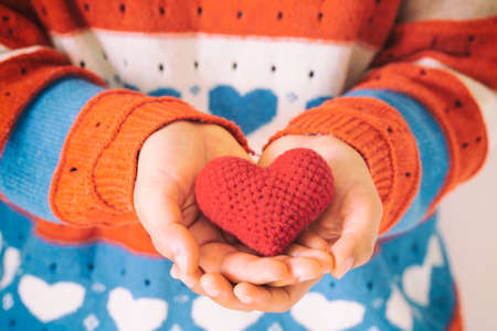 Women wear knit shirt hand holding red heart. Concept of love, hope, happy valentine, healthcare,organ donation,insurance, medical, World heart day, National Organ Donor day,World mental health day.の写真素材