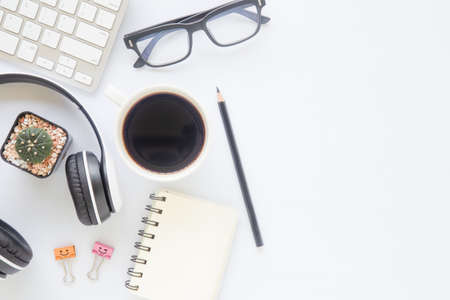 White desk office with laptop, smartphone and other work supplies with cup of coffee. Top view with...