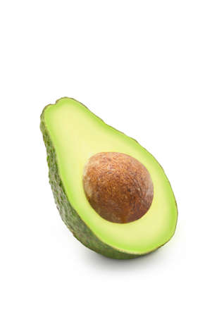 Half sliced ripe organic avocado with seed on white isolated background with clipping path....