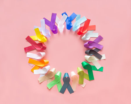 Colorful ribbons bow on pastel pink background in top view flat lay with copy space for text. World cancer day campaign concept on February 4, cancer awareness. National cancer survival day.の写真素材
