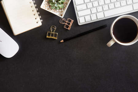 Black desk office with laptop, smartphone and other work supplies with cup of coffee. Top view with copy space for input the text. Designer workspace on desk table essential elements on flat lay.の写真素材