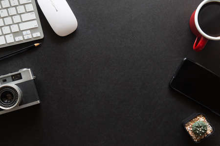 Black desk office with laptop, smartphone and other work supplies with cup of coffee. Top view with...