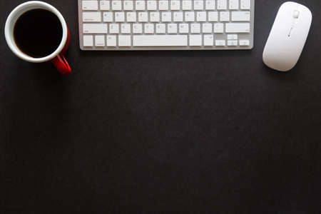 Black desk office with laptop, smartphone and other work supplies with cup of coffee. Top view with copy space for input the text. Designer workspace on desk table essential elements on flat lay.の写真素材