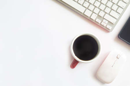 White desk office with laptop, smartphone and other work supplies with cup of coffee. Top view with...