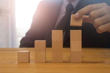 Business man gambling placing wooden block. Business concept  investment target and growth success...