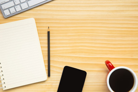 wood desk office with laptop, smartphone and other work supplies with cup of coffee. Top view with copy space for input the text. Designer workspace on desk table essential elements on flat lay.の写真素材